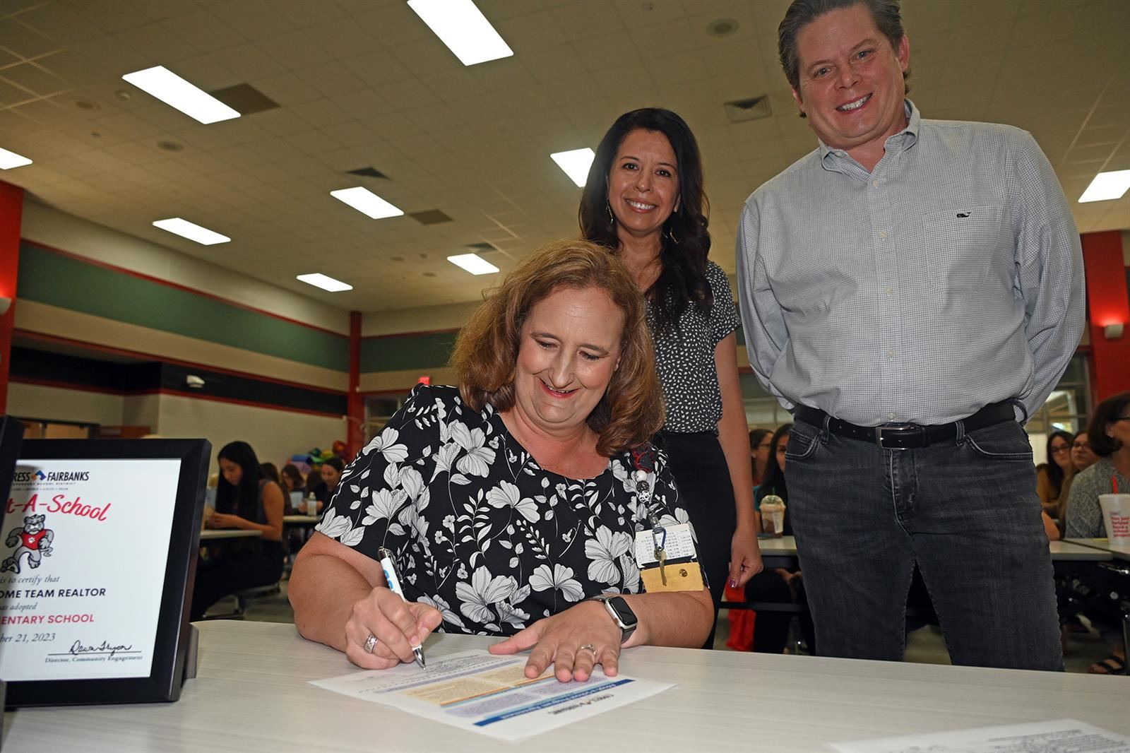 Kyla Mote, Black Elementary School principal, signs an Adopt-a-School partnership agreement.